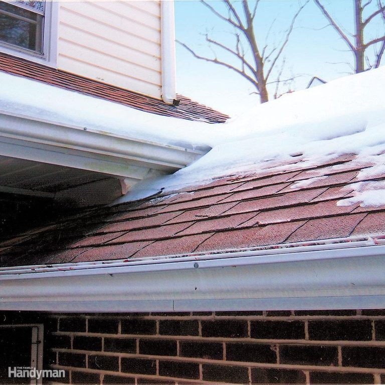 A brick house with snow on the roof and windows.