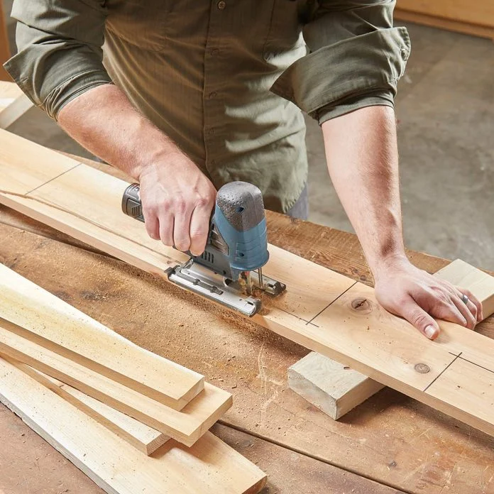 A person using an electric sander on wood.