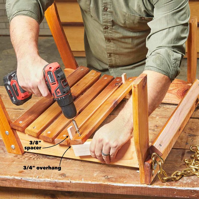 A man using a drill to make something out of wood.