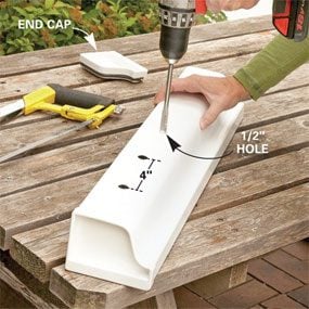 A person using a drill to make holes in the side of a planter.