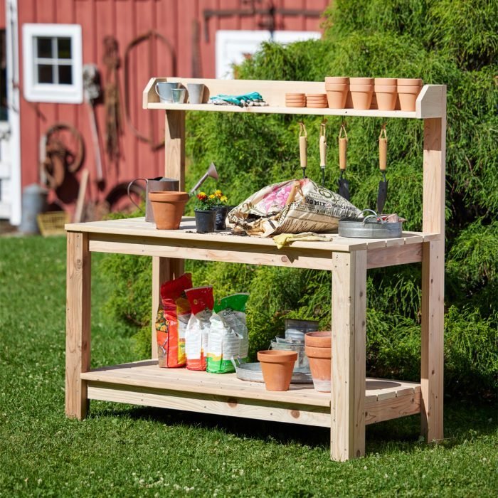 A wooden bench with pots and plants on it.