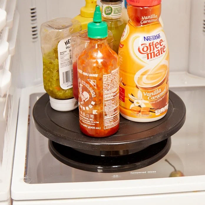 A bottle of juice and other condiments on the bottom shelf.