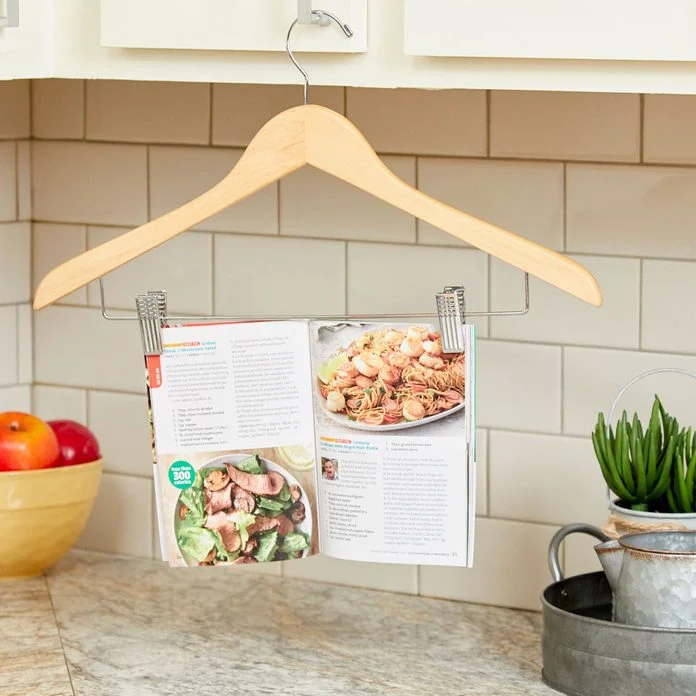 A wooden hanger with a magazine rack hanging from it.