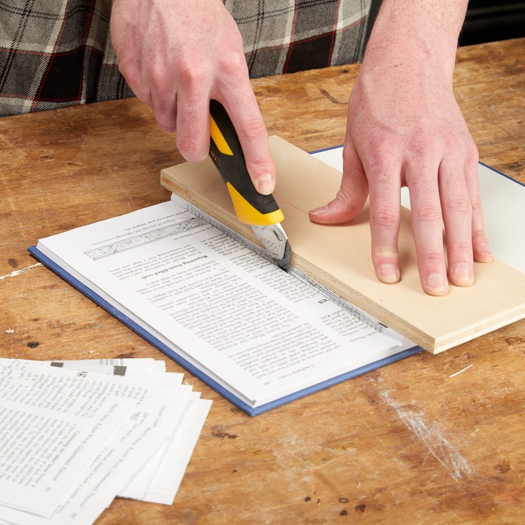 A person using a pair of scissors to cut paper.