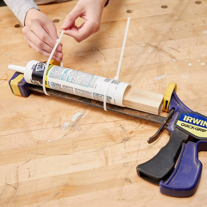 A person is using a glue gun to fix something.