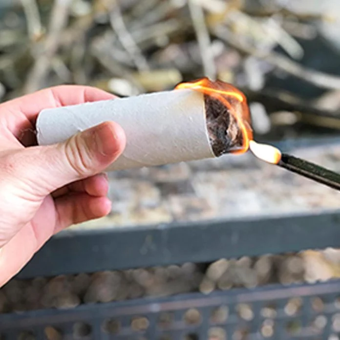 A person is lighting up their cigarette holder.