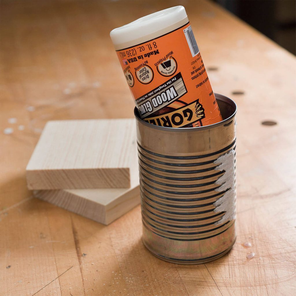 A can of peanut butter and some blocks on top of a table.