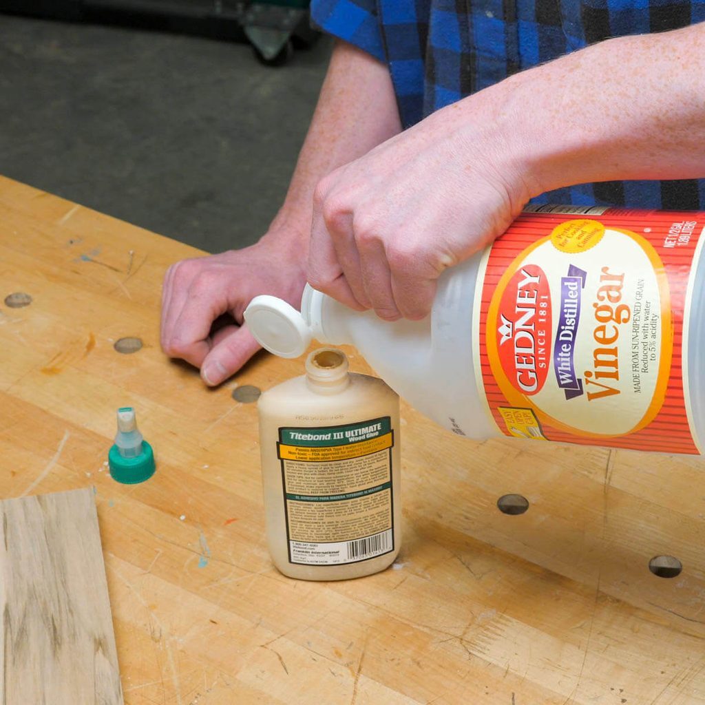 A person is pouring glue onto a bottle.