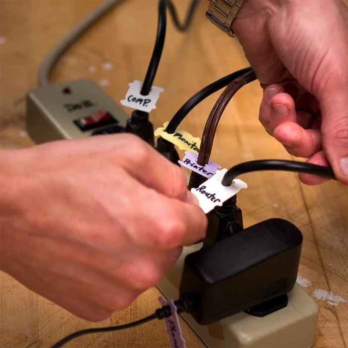 A person is working on the wires of an electrical device.